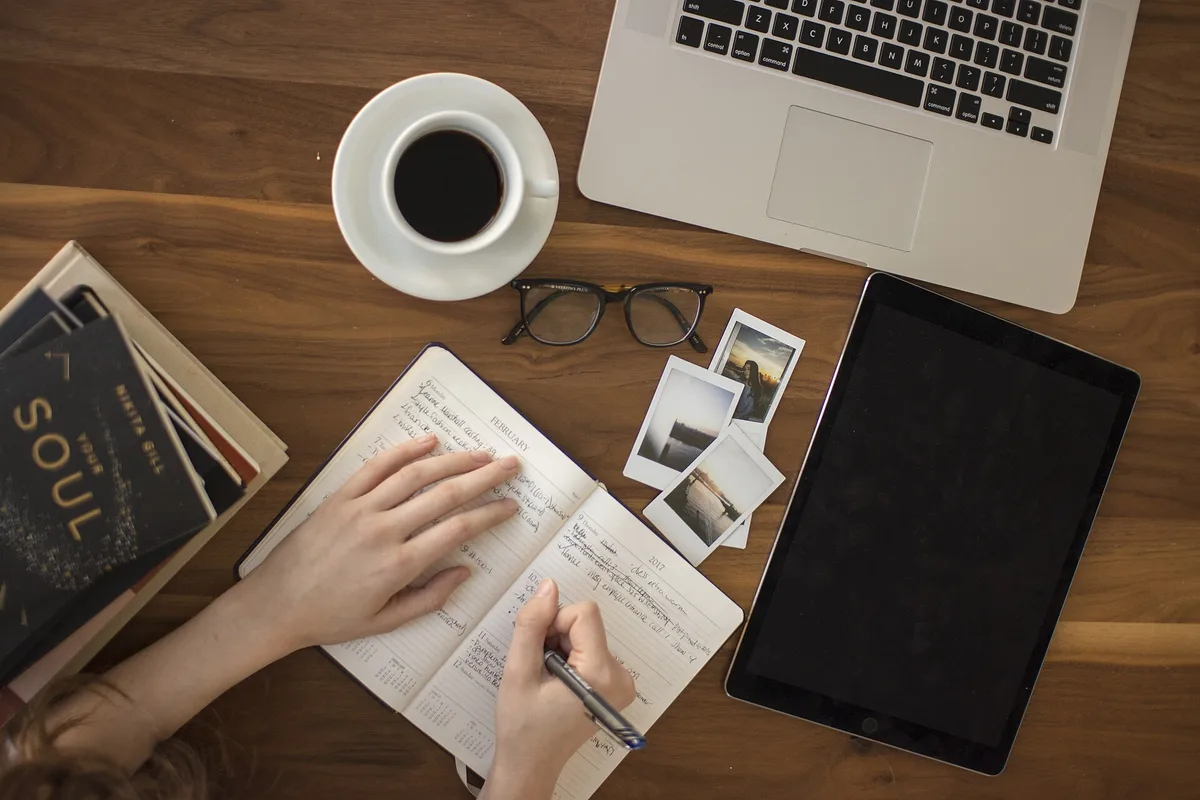 Persona escribiendo sus logros en un cuaderno para superar el síndrome del impostor